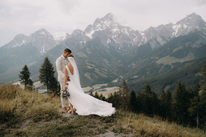 Brautpaar in den Bergen mit Blick auf die Alpenlandschaft bei einer Hochzeit in Kärnten